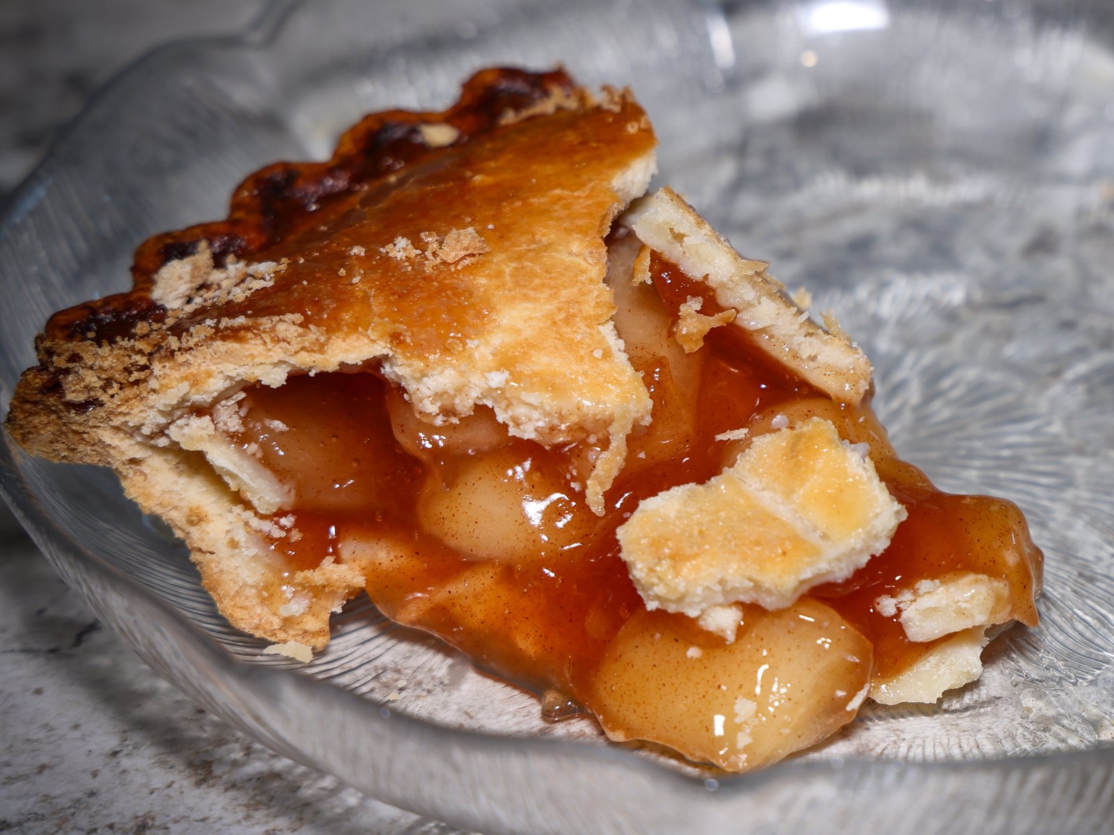 Slice of apple pie in a glass pie dish
