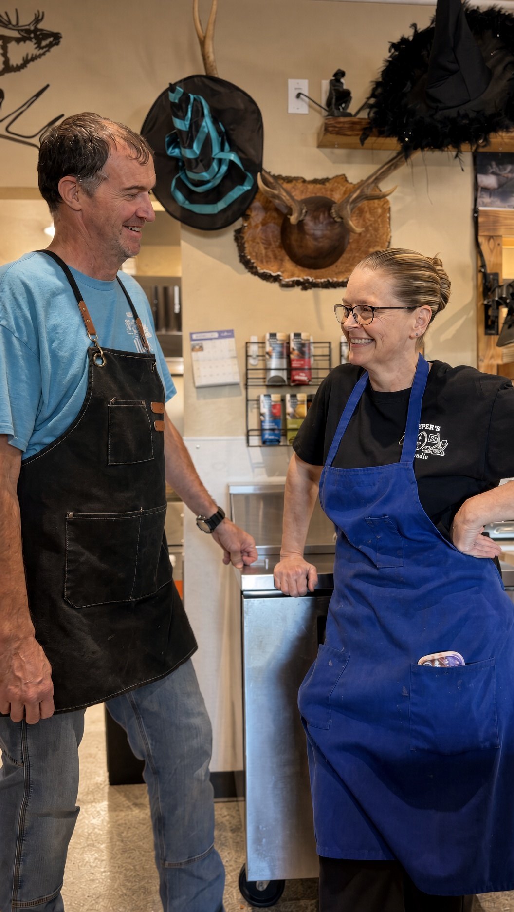 Matt and Mandie in their aprons, laughing by the counter